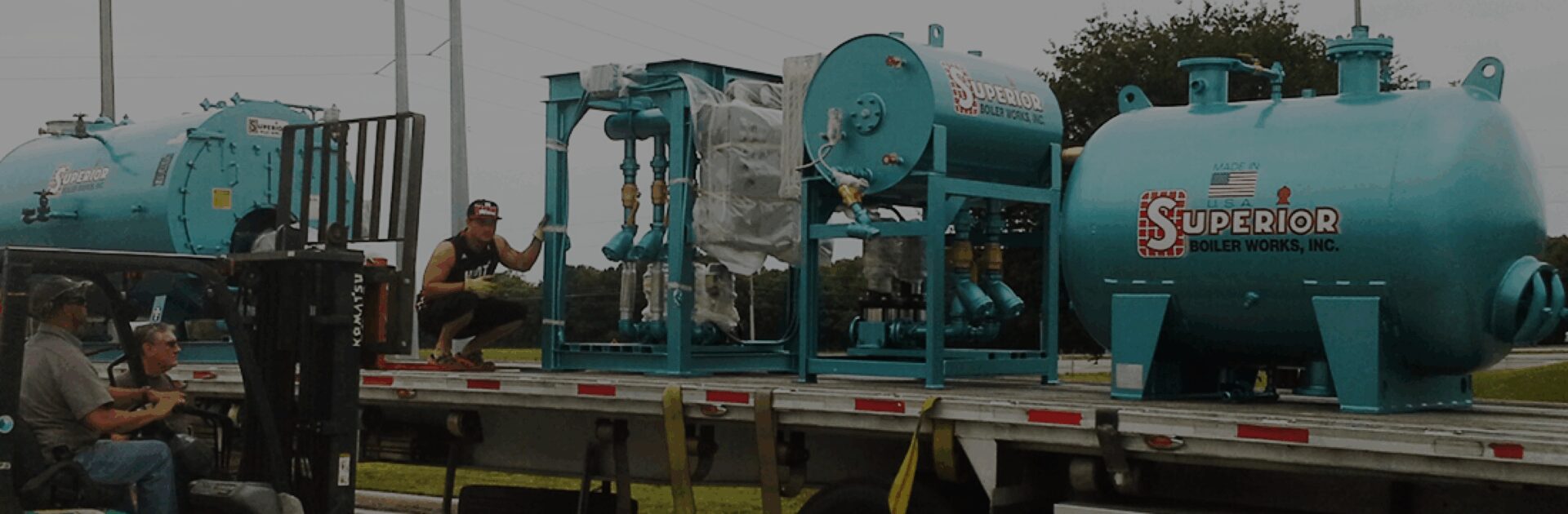 Blue industrial equipment loaded on a truck.